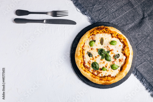 Traditional Margherita Pizza with basil, tomato, olive oil, mozzarella on a rustic background