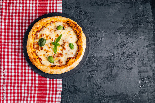 Traditional Margherita Pizza with basil, tomato, olive oil, mozzarella on a rustic background