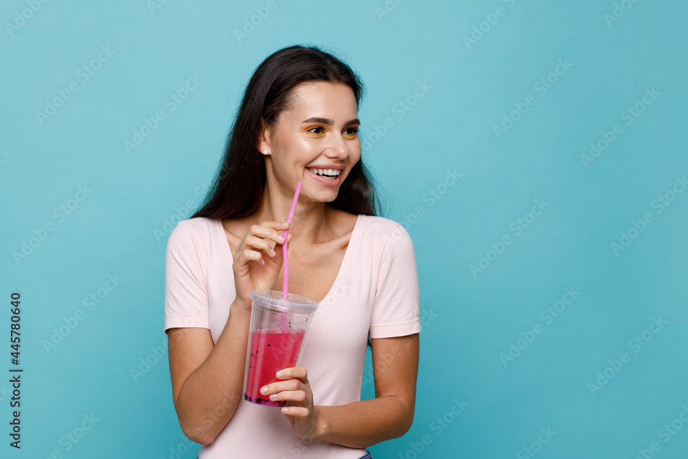 Young girl drinking fresh juice from plastic cup take-out food. Woman with berry lemonade on blue background. Summer cold drinks. Young girl drinking fresh juice from plastic cup take-out food. Woman with berry lemonade on blue background. Summer cold drinks.