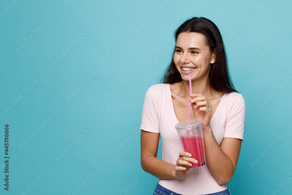Young girl drinking fresh juice from plastic cup take-out food. Woman with berry lemonade on blue background. Summer cold drinks. Young girl drinking fresh juice from plastic cup take-out food. Woman with berry lemonade on blue background. Summer cold drinks.