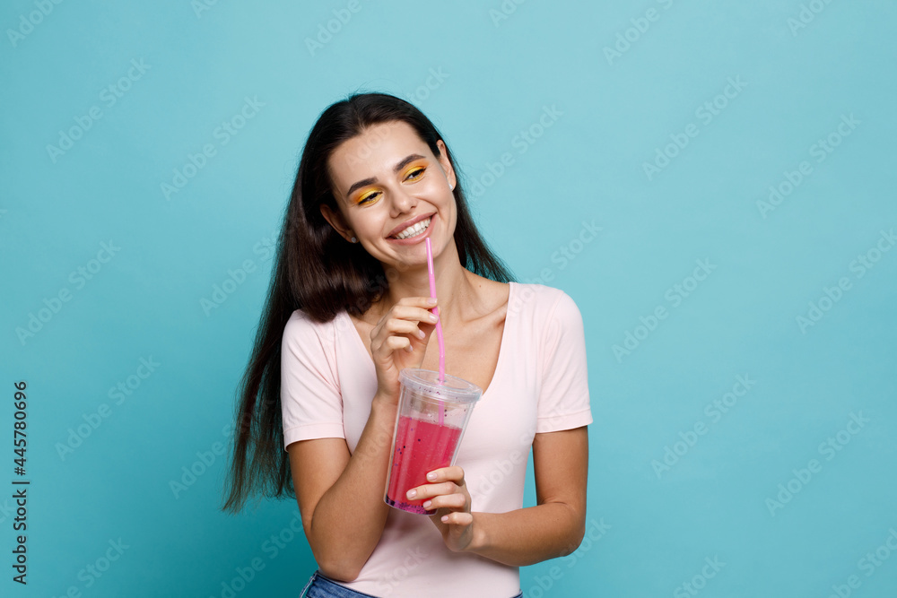 Young girl drinking fresh juice from plastic cup take-out food. Woman with berry lemonade on blue background. Summer cold drinks. Young girl drinking fresh juice from plastic cup take-out food. Woman with berry lemonade on blue background. Summer cold drinks.