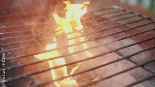 Empty hot barbecue grill with a flame of fire and smoke is burning, super slow motion.