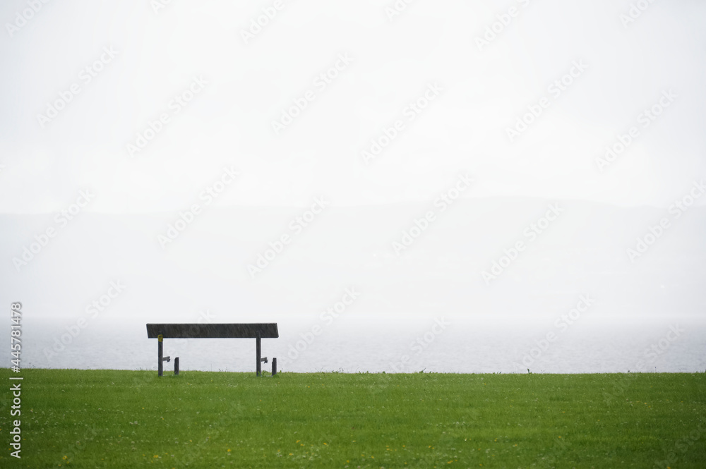 Lonely empty bench in open tranquil landscape by the sea for mindfulness and meditation