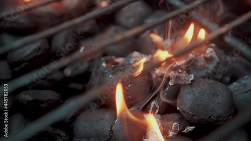 Empty hot charcoal barbecue BBQ grill with a large flame of fire and smoke is burning in restaurant. Super slow motion. Close up.