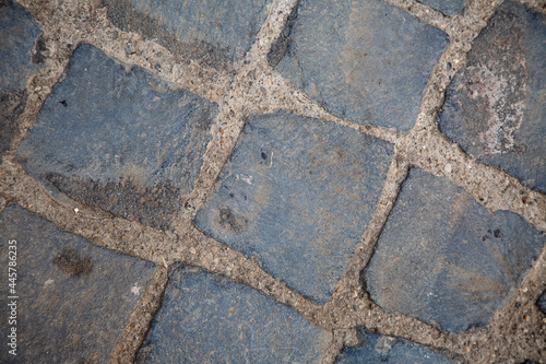top view to grey square cobblestone pavement. Diagonal geometric composition. Street surface. Wallpaper and background picture. traditional italian anti-seismic historical wall. Stone bricks.  photo
