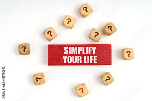 On the table are cubes with questions and a red plaque with the inscription - Simplify Your Life
