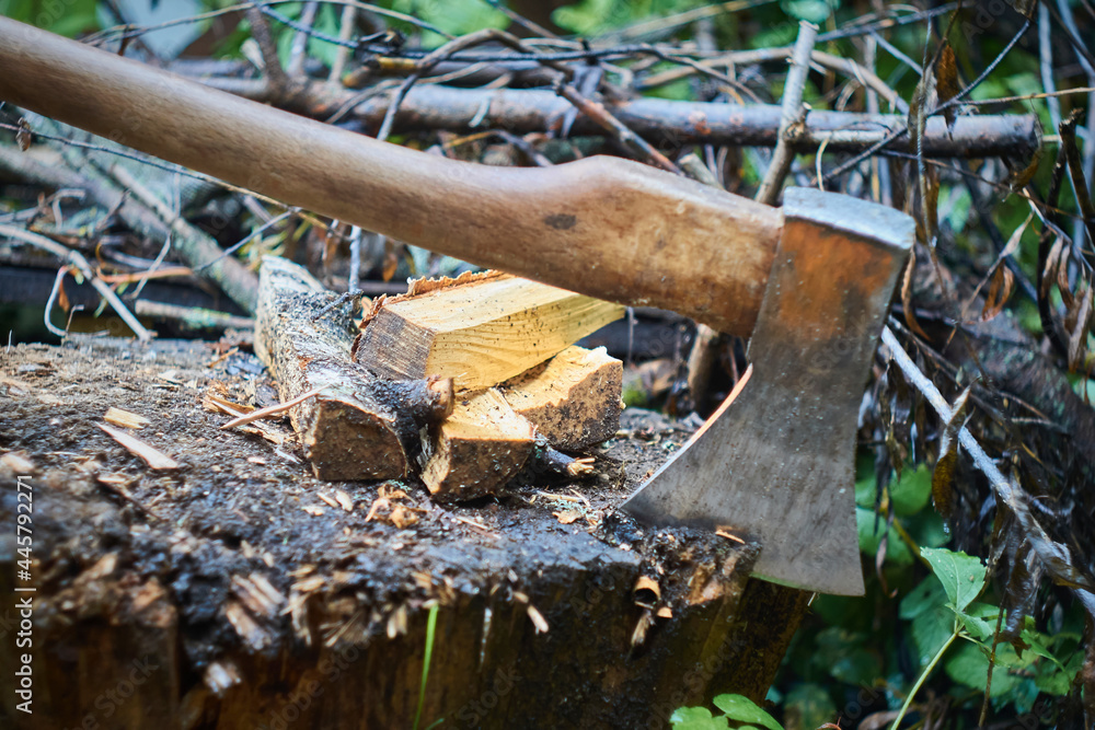 An axe and firewood on the tree stump An axe and firewood on the tree stump