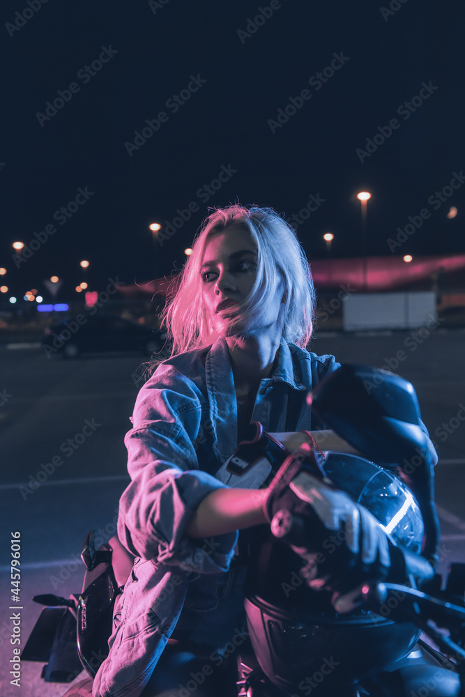 portrait of a girl in the rays of neon light on a motorbike at night in an empty parking lot portrait of a girl in the rays of neon light on a motorbike at night in an empty parking lot