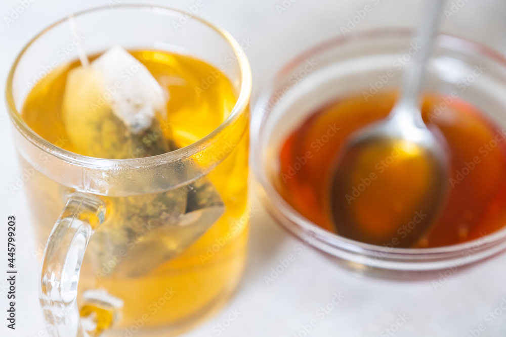 Raw honey and glass mug of tea
