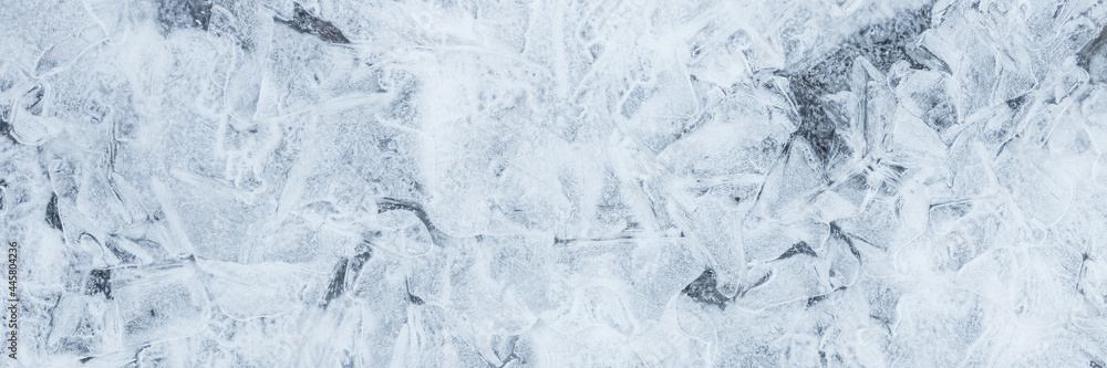 Obraz premium Ice texture. Beautiful winter frosty background. Cool ice patterns on the frozen surface of the water. Cold weather and frost. Winter season. Wide panoramic texture for background and design.