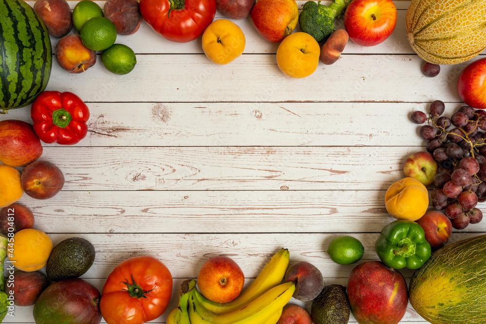 frame of seasonal fruits and vegetables. Bunch of red grapes, melon de la galia, red watermelon, ripe yellow peaches, tomatoes and red peppers, African mangoes and avocados, red apples and nectarines frame of seasonal fruits and vegetables. Bunch of red grapes, melon de la galia, red watermelon, ripe yellow peaches, tomatoes and red peppers, African mangoes and avocados, red apples and nectarines