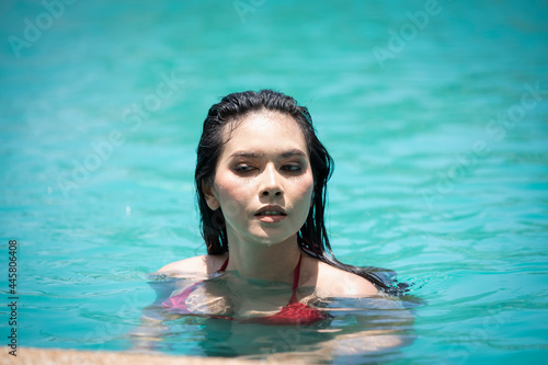 Beautiful asian women relaxing at the luxury poolside