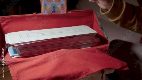 Sacred Buddhist scriptures.
It looks like the person turns the pages and lets see the sacred scriptures. To the side you can see the prayer wheel and the Mala, objects of prayer photo