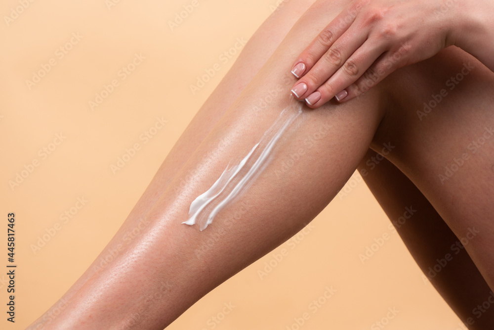 Applying moisturizer cream on legs. Cellulite or anti cellulite treatment. Cosmetic cream on woman leg with clean soft skin. Applying moisturizer cream on legs. Cellulite or anti cellulite treatment. Cosmetic cream on woman leg with clean soft skin.