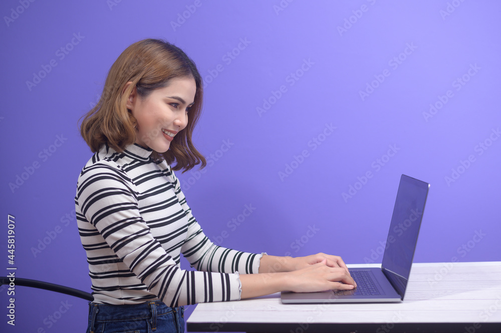 Young beautiful woman is working with her computer over blue background.. Young beautiful woman is working with her computer over blue background..