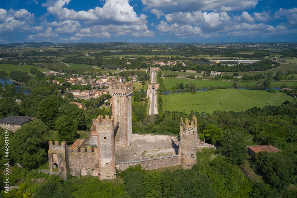 Obraz premium Aerial view of the Italian historic castle Castello Scaligero on a hill, view of the Mincio river. Castle Scaligero in Valeggio sul Mincio, Italy. Aerial panorama of the Scaligero castle, Verona.