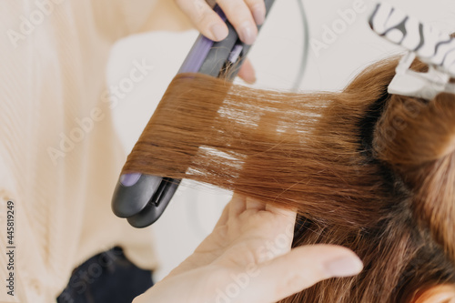 Asian woman model is dressing her hair by the hairdresser in studio room.