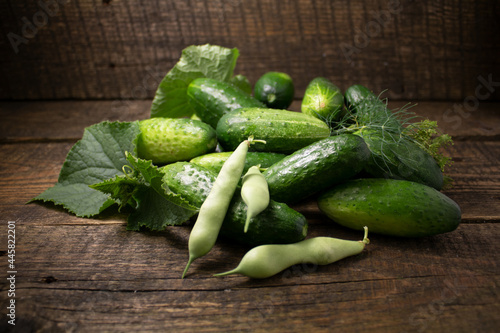 Cuadro en lienzo Cucumbers and string beans on a wooden background
