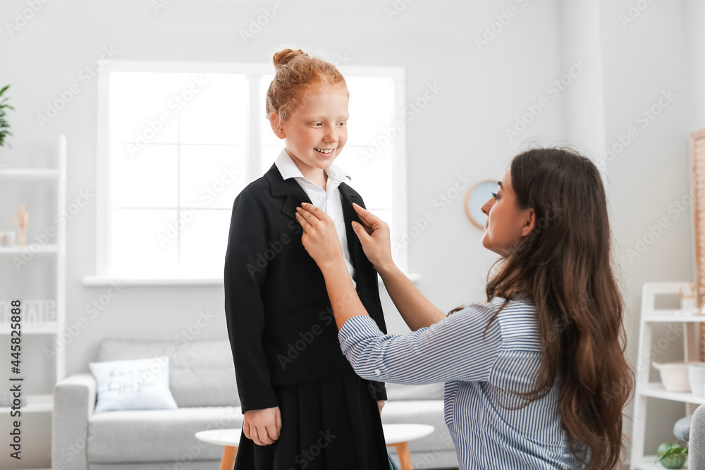 Mother getting her little daughter ready for school