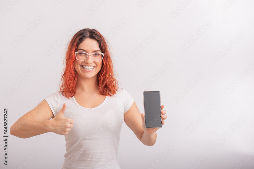 Caucasian woman holding phone with blank screen and showing thumb up on white background. Caucasian woman holding phone with blank screen and showing thumb up on white background.