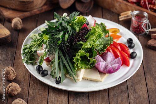 Fresh vegetables platter with greens on decorated background