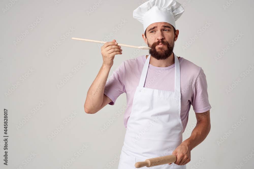 professional chef in uniform with a spoon in his hands work light background professional chef in uniform with a spoon in his hands work light background