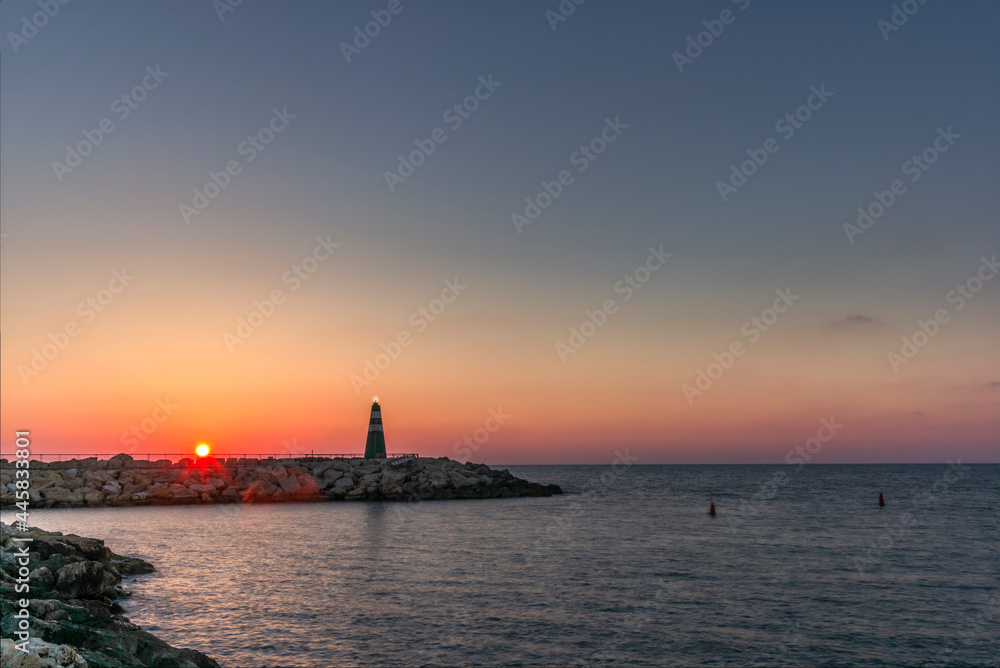 The small lighthouse at the entrance of the harbour in Tel Aviv at sunset