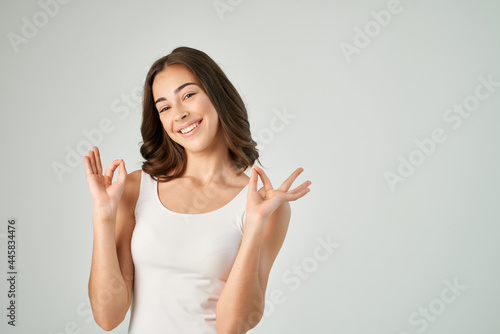 cheerful brunette gesturing with her hands in a white t-shirt model lifestyle