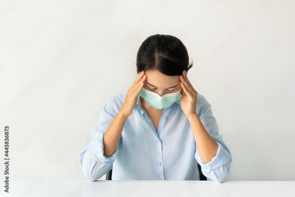 Sickness Asian girl wearing a medical face mask sitting at home over white background. Sickness Asian girl wearing a medical face mask sitting at home over white background.