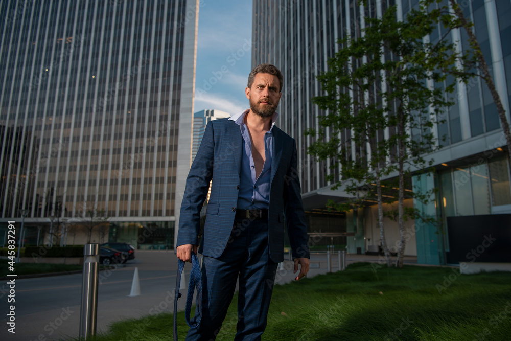 Caucasian business man in suit comes out office. concept of end working day. Sexy fashion businessman. Caucasian business man in suit comes out office. concept of end working day. Sexy fashion businessman.