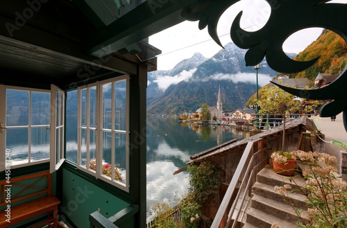 Scenic view of beautiful Hallstatt through the window with lakeside village and mountains reflected on the smooth lake water in beautiful Salzkammergut Region of Austrian Alps