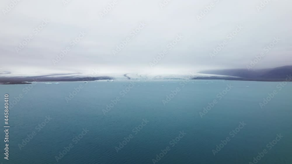 Aerial View of Icebergs Scattered in the Vast Blue Ocean and Clear Skies Aerial View of Icebergs Scattered in the Vast Blue Ocean and Clear Skies