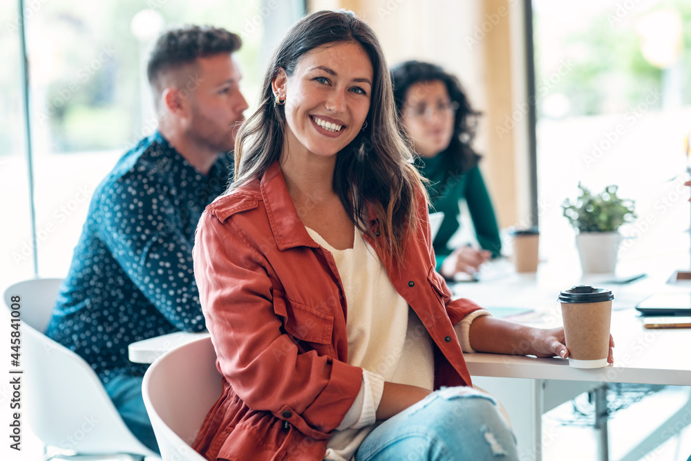 © nenetus - Beautiful businesswoman is looking at camera while her colleagues are working on coworking place.