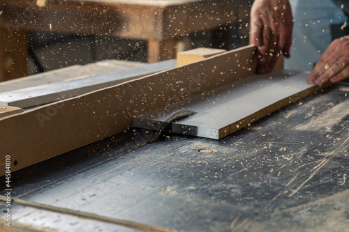A carpenter works on woodworking the machine tool. Carpenter working on woodworking machines in carpentry shop.