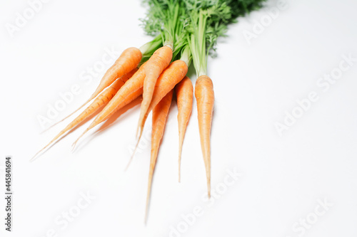 Bunch of fresh carrots on white table.