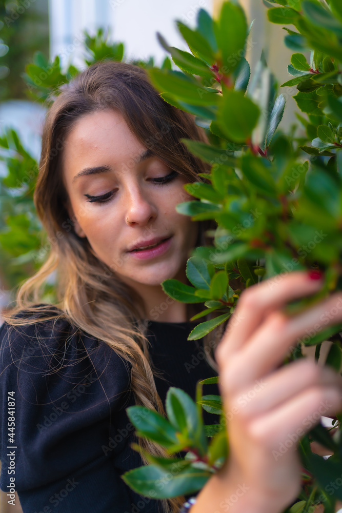 A young blond Caucasian woman next to some green plants in spring, seductive look A young blond Caucasian woman next to some green plants in spring, seductive look