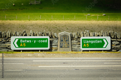 Road signs and milestone on the A5 road outside Corwen between Betws y Coed and Llangollen in North East Wales photo