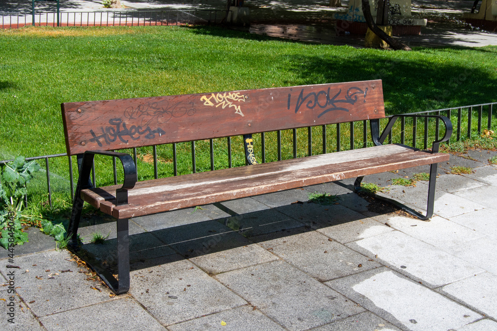 Banco de madera con grafitis en el parque en la ciudad Banco de madera con grafitis en el parque en la ciudad