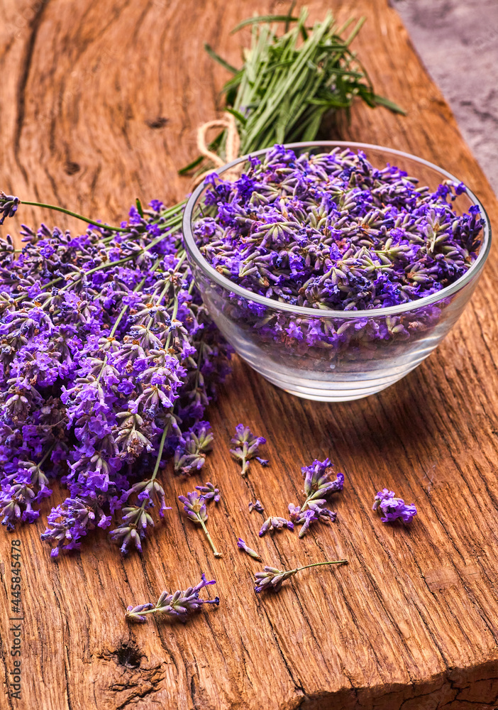 Bunch of lavender and lavender vlowers in glass bowl on wooden board Bunch of lavender and lavender vlowers in glass bowl on wooden board