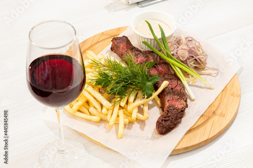 Beef steak with French fries, herbs and red wine