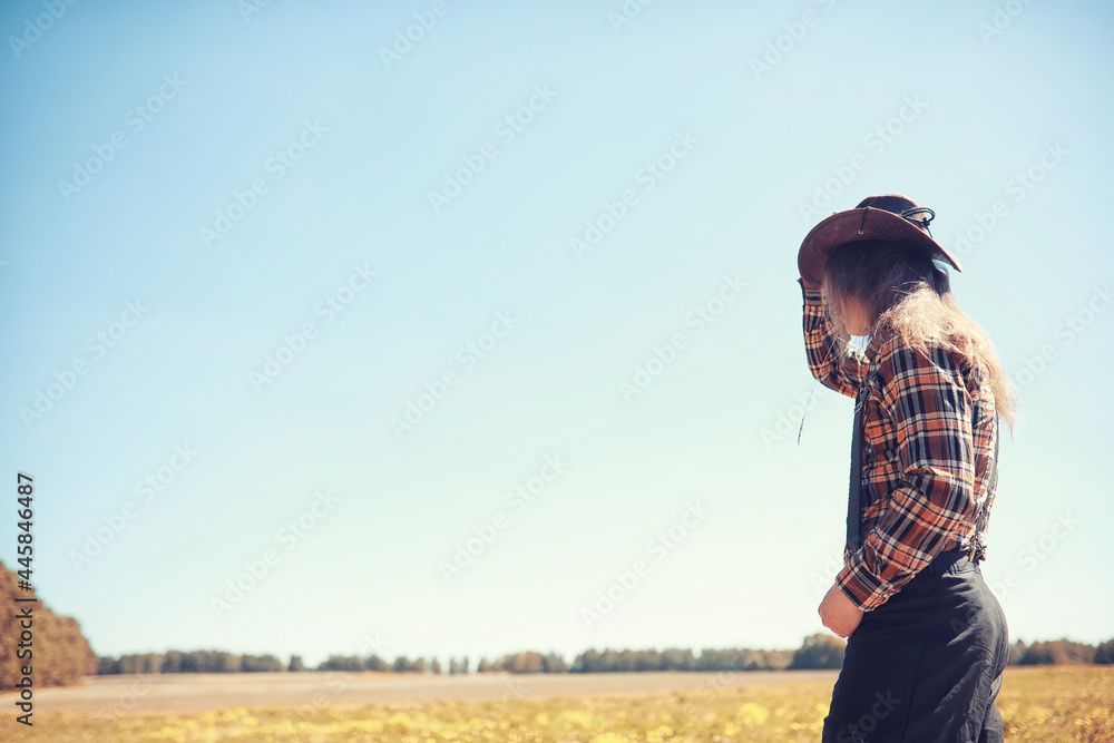 Cowboy with hat in a field in autumn Cowboy with hat in a field in autumn