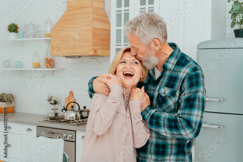 Retired husband and wife hug each other at home