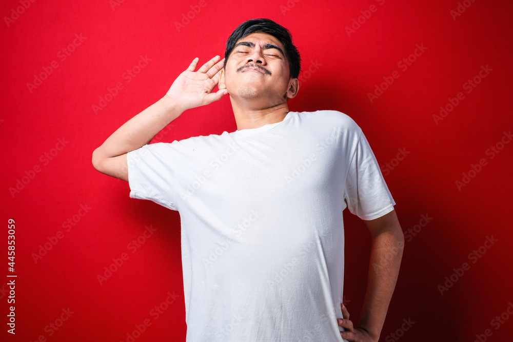 Young beautiful asian boy wearing white tshirt stretching back, tired and relaxed, sleepy and yawning for early morning Young beautiful asian boy wearing white tshirt stretching back, tired and relaxed, sleepy and yawning for early morning