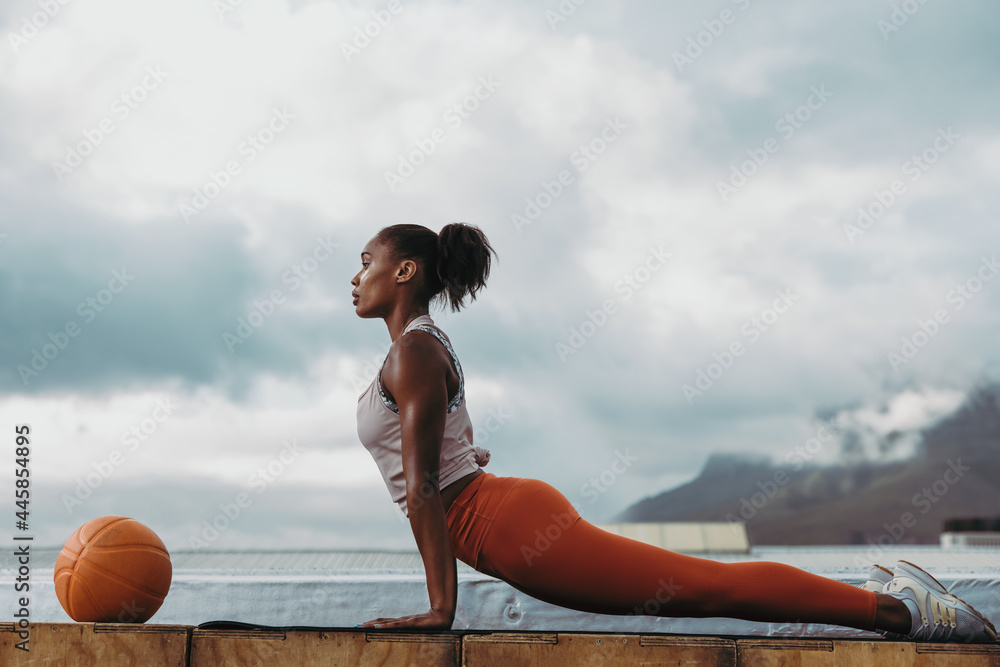 © Jacob Lund - Sportswoman doing cobra pose yoga on rooftop © Jacob Lund - Sportswoman doing cobra pose yoga on rooftop