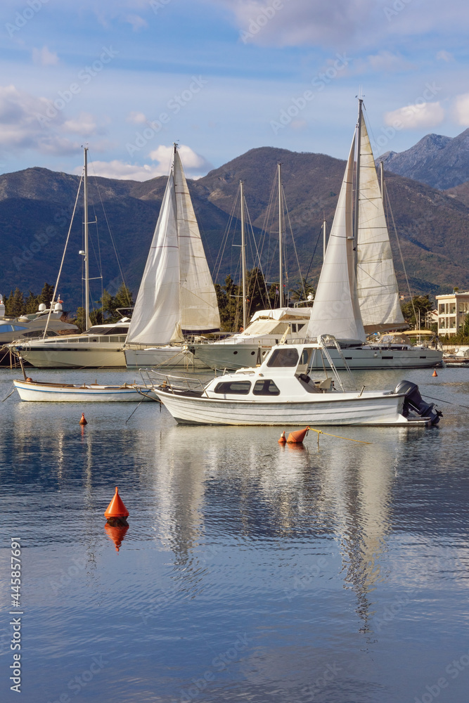 Obraz premium Beautiful winter Mediterranean landscape. Sailboats and fishing boats on water. Montenegro, Adriatic Sea. View of Kotor Bay near Tivat city