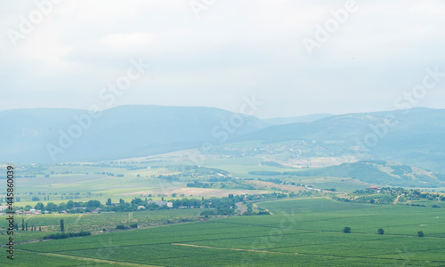 Summer valley landscape with road, cypresses and mountains in Crimea. Photo of small village located among mountains