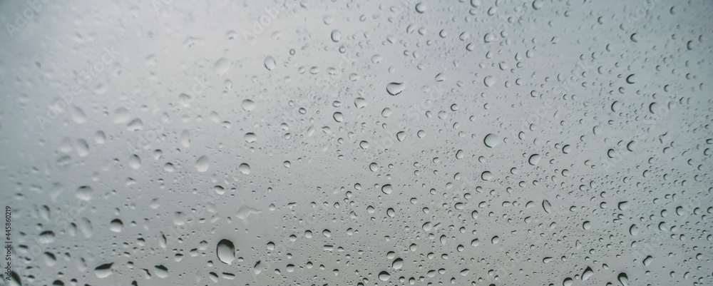 Horizontal water drops background. Wide close up on rain droplets with sharp focus on the window. Concept of moody day, nostalgia, home time and feelings. Horizontal water drops background. Wide close up on rain droplets with sharp focus on the window. Concept of moody day, nostalgia, home time and feelings.