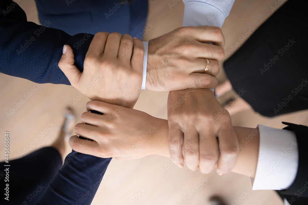 United business team holding wrists and making unbreakable hand square, community and support symbol. Group of engaged employees keeping teamwork, motivation, friendship spirit. Close up cropped shot United business team holding wrists and making unbreakable hand square, community and support symbol. Group of engaged employees keeping teamwork, motivation, friendship spirit. Close up cropped shot