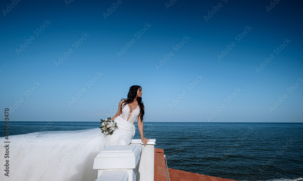 luxurious young bride in an expensive fashionable wardrobe poses for a wedding photo shoot in a luxury resort town
