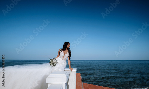 luxurious young bride in an expensive fashionable wardrobe poses for a wedding photo shoot in a luxury resort town